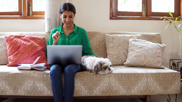 woman-sitting-on-couch-with-dog-and-laptop