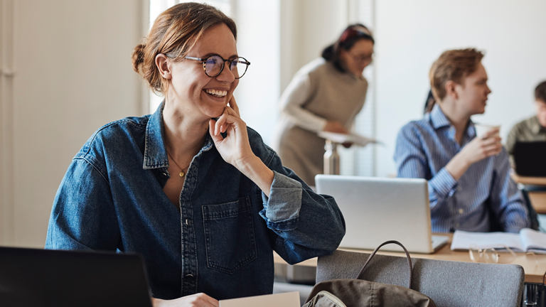 smiling-woman-in-classroom-setting-looking-to-side (1)